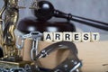 Word ARREST composed of wooden letters.