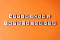 Word artificial intelligence. The phrase AI is laid out in wooden letters top view. Orange flat lay background.