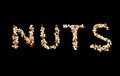 Word arts `Nuts` made of mixed nuts of almond, hazelnut, peanut and cashew on black background Royalty Free Stock Photo
