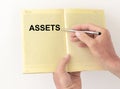 Word Assets on notebook in male hands. Financial accounting. Money concept Royalty Free Stock Photo