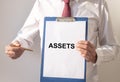 Word Assets on paper in businessman hand Financial accounting. Money concept Royalty Free Stock Photo