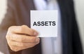 Word Assets on paper in businessman hand Financial accounting. Money concept Royalty Free Stock Photo