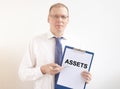 Word Assets on paper in businessman hand Financial accounting. Money concept Royalty Free Stock Photo