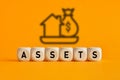 The word assets written on wooden cubes with assets icon on yellow background. Asset management or financial accounting