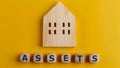 The word assets written on wooden cubes with assets icon on yellow background. Asset management or financial accounting concept
