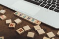 A word AUGUST made of wooden blocks with letters vocabulary game seasons of the year concept