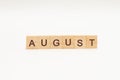 Word AUGUST made of wooden blocks on white background. Month of year. The end of the summer