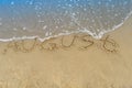 The word August is written on the sand of a beach by the sea. Washed off by a wave. The inscription disappears. End of Royalty Free Stock Photo