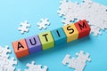 Word Autism made of colorful cubes and puzzle on light blue background Royalty Free Stock Photo