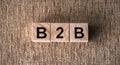 The word B2B business to business on wooden blocks on a brown background top view Royalty Free Stock Photo