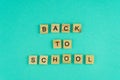 Word back to school. The phrase is laid out in wooden letters. Top view. Motivation. Blue background. Copy space