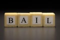 The word BAIL written on wooden cubes isolated on a black background