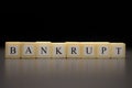 The word BANKRUPT written on wooden cubes isolated on a black background