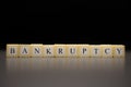 The word BANKRUPTCY written on wooden cubes isolated on a black background