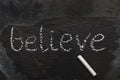 The word BELIEVE written with chalk on black stone Royalty Free Stock Photo