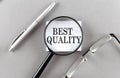 Word BEST QUALITY on sticky through magnifier on grey background Royalty Free Stock Photo