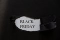 Word BLACK FRIDAY printed on a white background with black torn paper