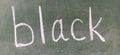 The word BLACK written by hand on a green school board. Black color. Printed letters Royalty Free Stock Photo