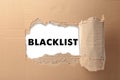 Word Blacklist on white paper, view through hole in cardboard Royalty Free Stock Photo