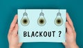 The word blackout is standing under the blown lightbulbs, power cut out, uncertain energy supply Royalty Free Stock Photo