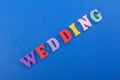 WEDDING word on blue background composed from colorful abc alphabet block wooden letters, copy space for ad text. Learning english Royalty Free Stock Photo