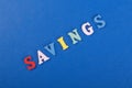 SAVINGS word on blue background composed from colorful abc alphabet block wooden letters, copy space for ad text. Learning english Royalty Free Stock Photo