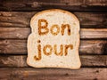 Word bonjour written on a toasted slice of bread