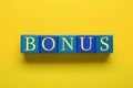 Word Bonus made of color cubes with letters on yellow background, top view Royalty Free Stock Photo