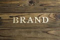 The word BRAND is lined with letters on a wooden background. Royalty Free Stock Photo