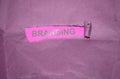 The word Branding written under torn paper with silver letters on pink background