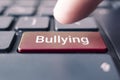 The word bullying on the computer keyboard. The concept of harassment intimidation and humiliation in the network