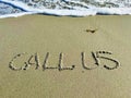 Word call us in the sand Royalty Free Stock Photo