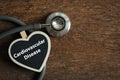 Word cardiovascular disease on heart-shaped board with a stethoscope. on wooden background. Medicine and cardiology concept Royalty Free Stock Photo