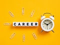 The word career on cubes with alarm clock and paper clips. Time for career planning or change. Beginning a new career Royalty Free Stock Photo