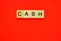 Word cash. Top view of wooden blocks with letters on red surface Royalty Free Stock Photo