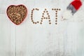 Word cat and food for pets in the heart shaped bowl and toy on wooden background. With love for cats concept. Top view Royalty Free Stock Photo