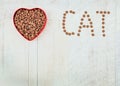 Word cat and food for pets in the heart shaped bowl on wooden background. With love for cats concept. Top view. Copy Royalty Free Stock Photo