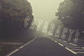 Word cataracts written on foggy, blurred road, danger autumn road