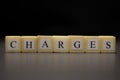 The word CHARGES written on wooden cubes isolated on a black background Royalty Free Stock Photo