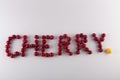 Word Cherry written by red fruits and one yellow on white background Royalty Free Stock Photo