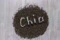 Word chia made from chia seeds on white wooden background. Healthy food.