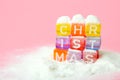 word christmas made of colorful letters blocks on white snow and pink background. Flat lay, top view - holidays, winter, christmas Royalty Free Stock Photo