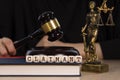 Word CLAIMANT composed of wooden dices. Wooden gavel and statue of Themis in the background