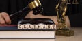 Word CLAIMANT composed of wooden dices. Wooden gavel and statue of Themis in the background