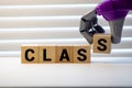 the word class on wooden blocks on a pink background