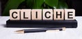 The word CLICHE is written on the wooden cubes of the diary near the handle Royalty Free Stock Photo
