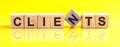 Word Clients is made of wooden building blocks lying on the table and on a light yellow background