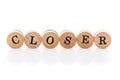 Word Closer from circular wooden tiles with letters children toy. Royalty Free Stock Photo