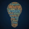 A word cloud forms the shape of a light bulb against a dark blue Royalty Free Stock Photo