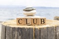 The word club from wooden cubes. The cubes are on the tree stump